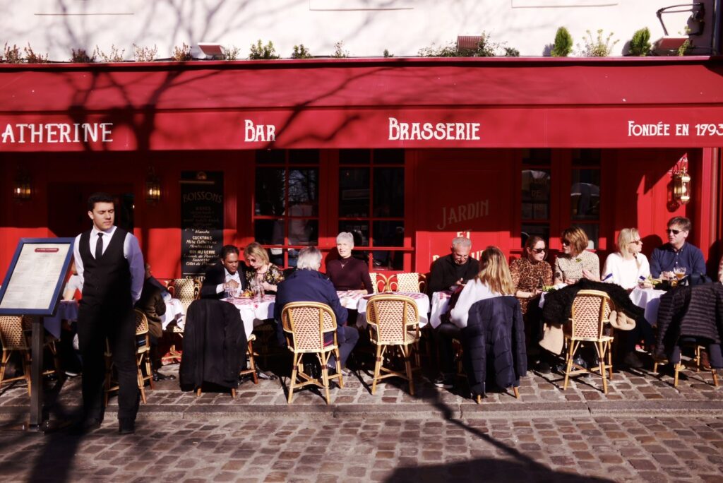 Terraza de un café parisino con toldo rojo